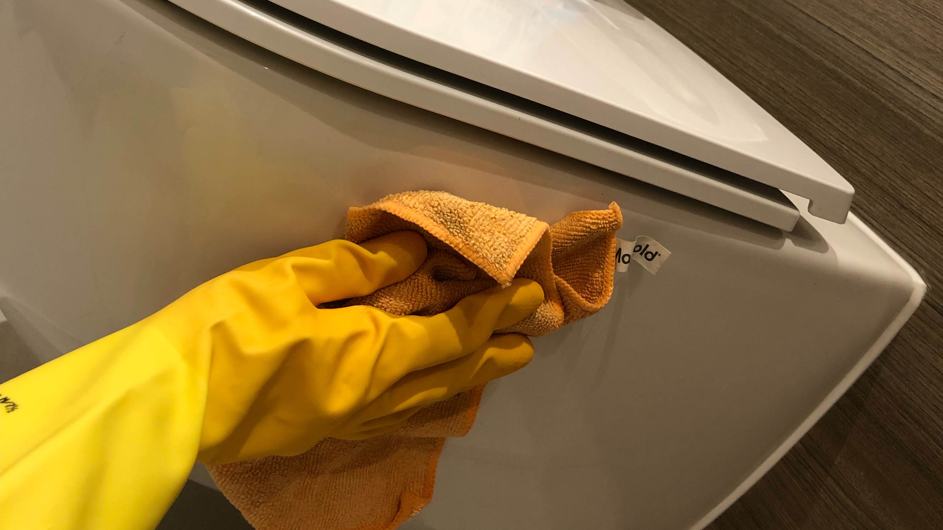 Lastik eldiven giyerken tuvaletin kenarını temizlemek için kullanılan mikrofiber bez