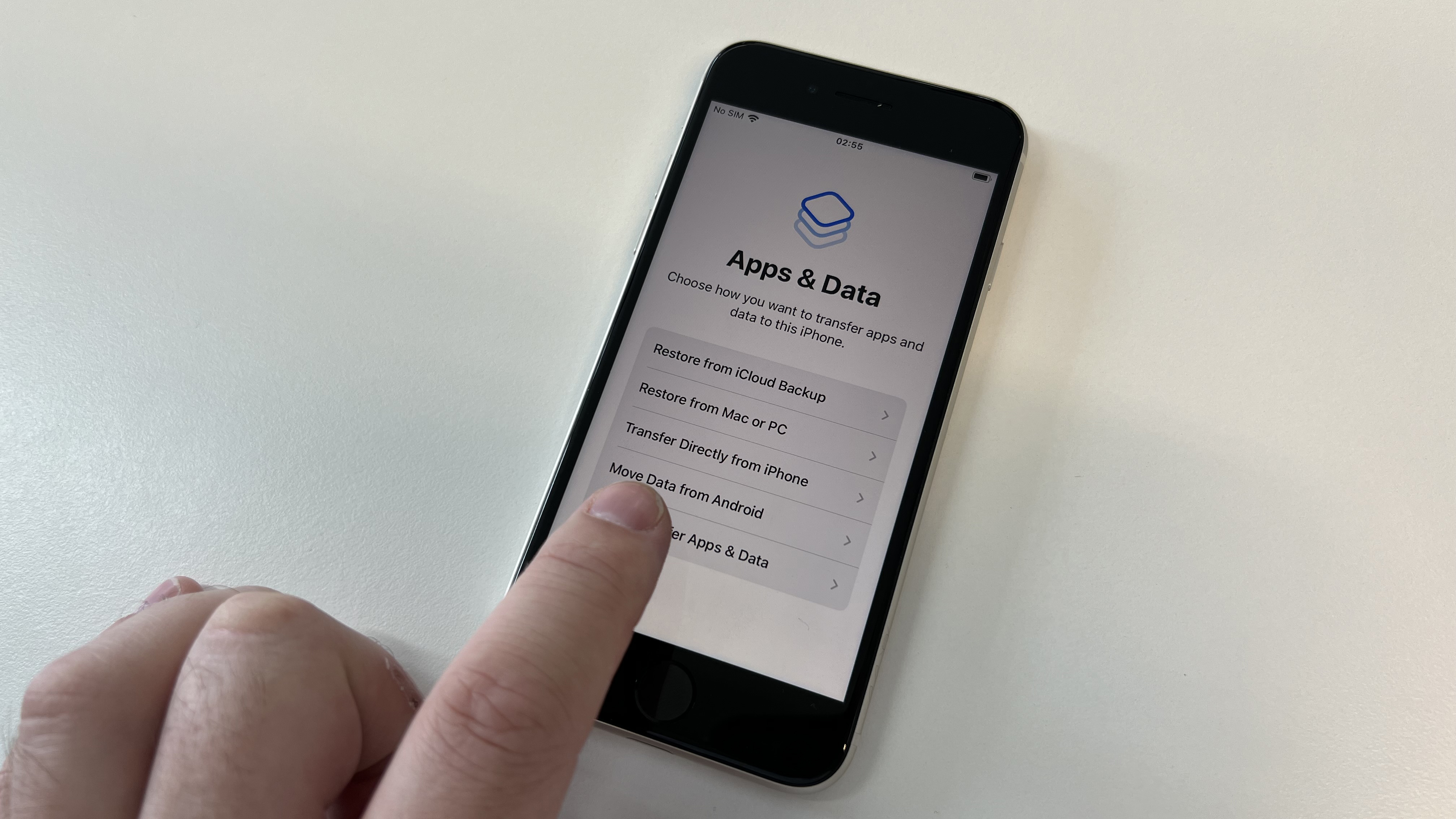 Kullanıcının verileri nereden içe aktarmak istediğini soran iPhone kurulum menüsü.  Android'den Verileri Taşı seçeneğini işaret eden bir parmak