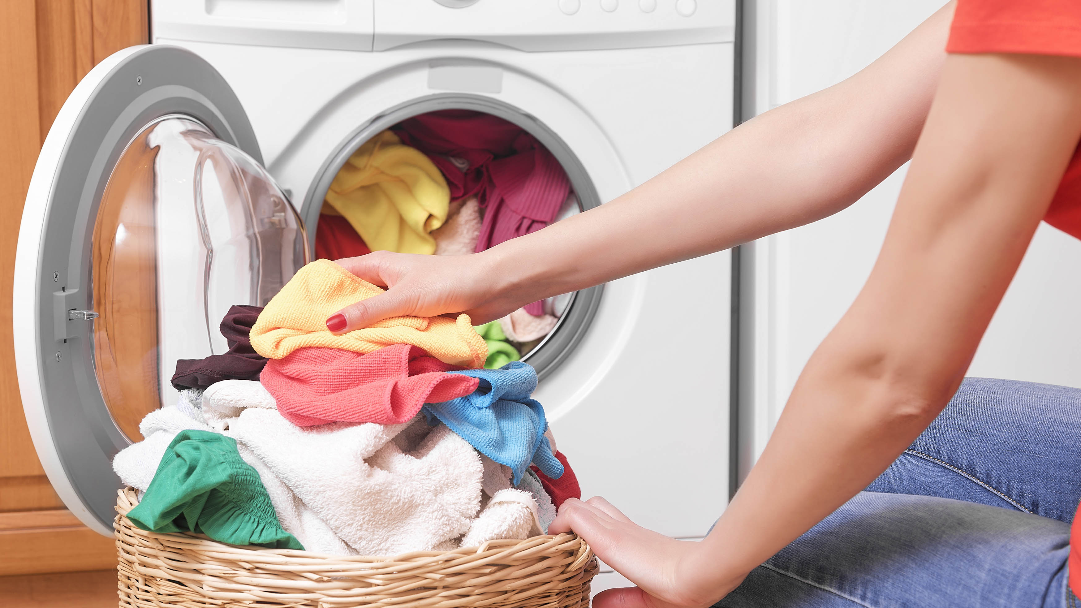 Çamaşır makinesine renkli giysiler yükleme