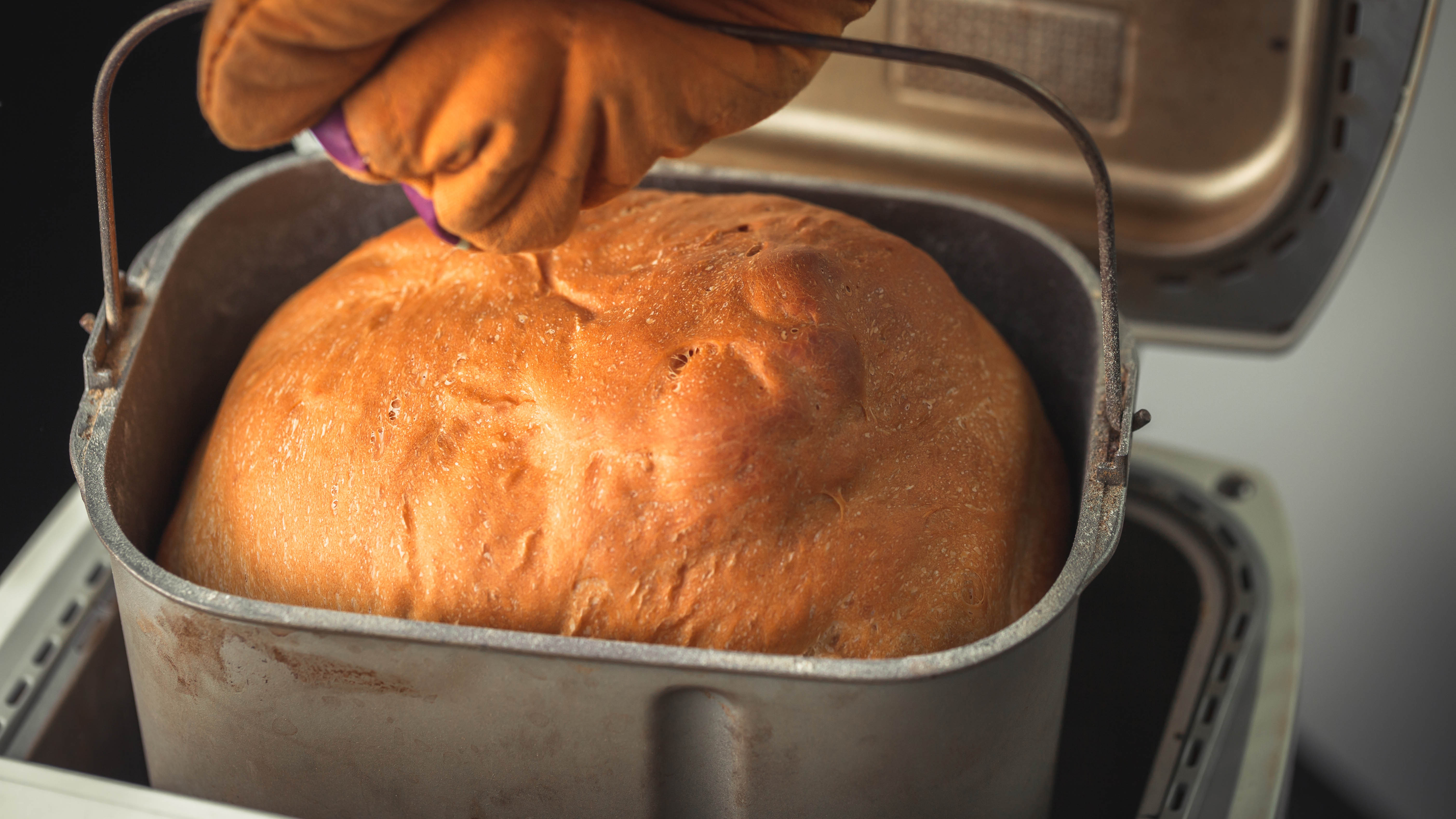 Bir ekmek makinesinden çıkarılan pişmiş bir somun ekmek