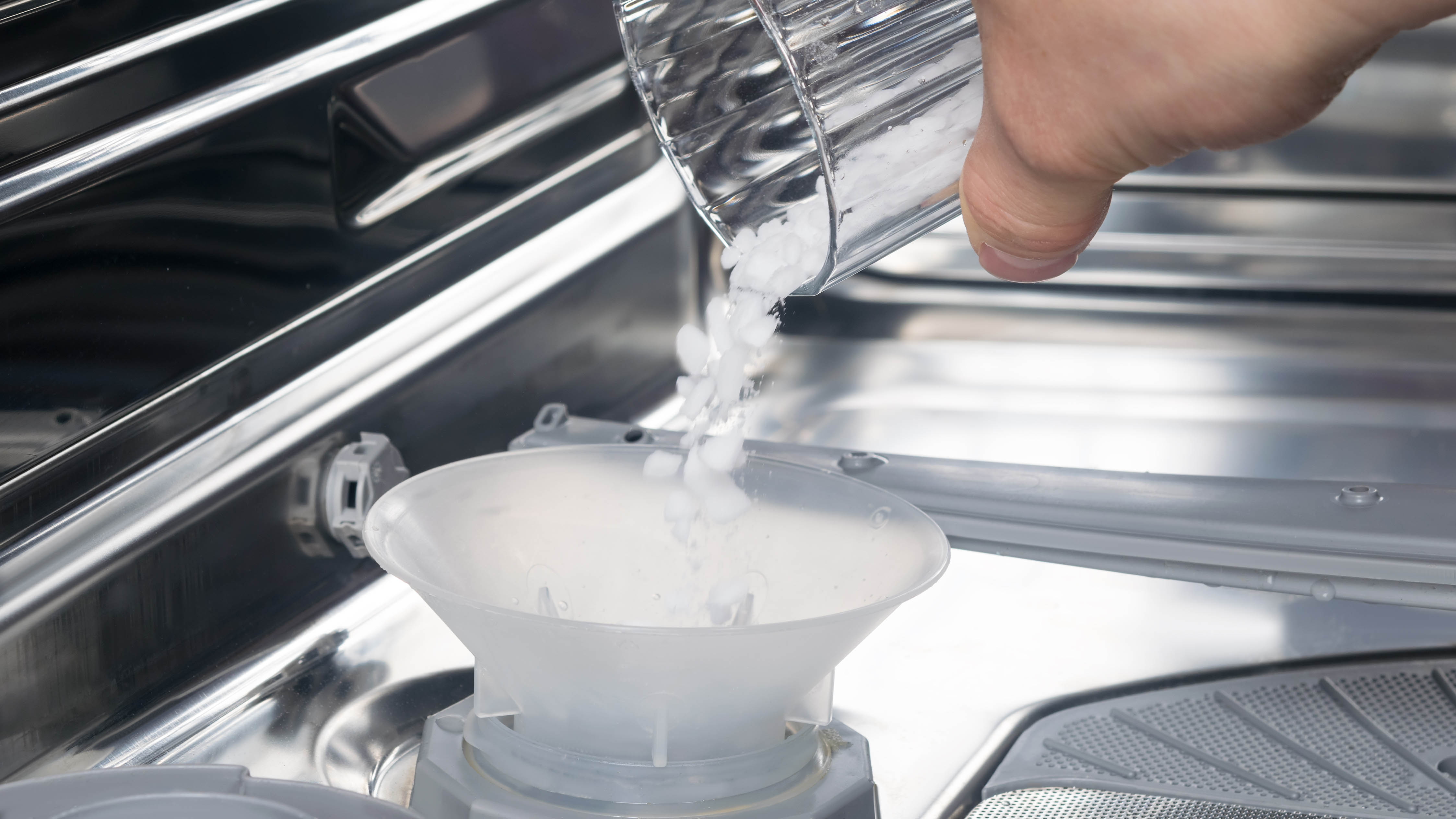 Bulaşık makinesinde tuz haznesine bulaşık makinesi tuzu ekleniyor